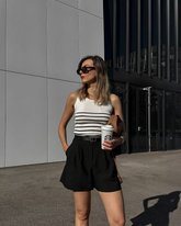 a lady wears a striped tank top with black shorts